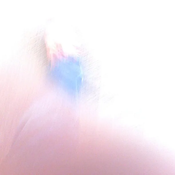An overexposed and blurred image showing indistinct motion with faint hints of blue, red, and skin tones in the center.