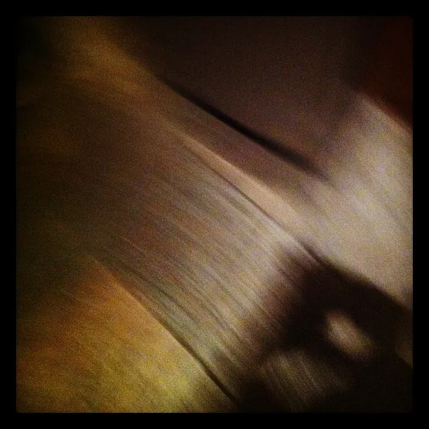 Blurred abstract image featuring diagonal streaks of brown, beige, and gray tones, likely captured in motion or low light.