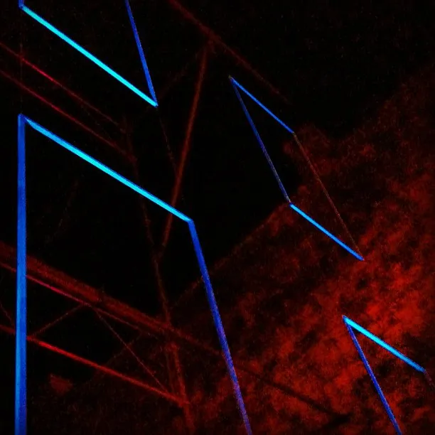 Geometric neon blue light shapes suspended in a dark space with red-lit scaffolding and textured background.