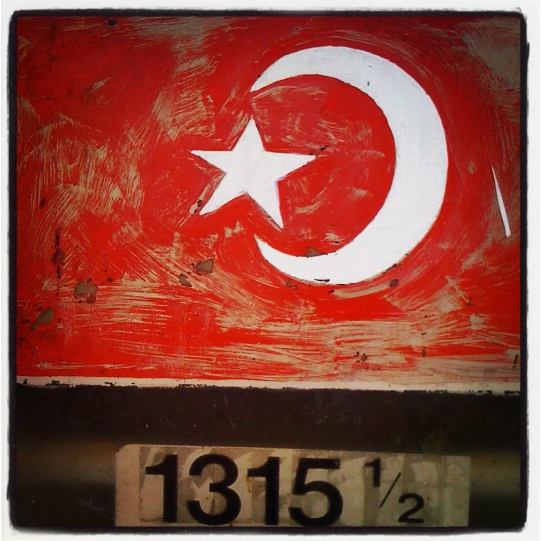 Red-painted surface with a white crescent moon and star symbol above a weathered address label reading “1315 ½” in bold black text.