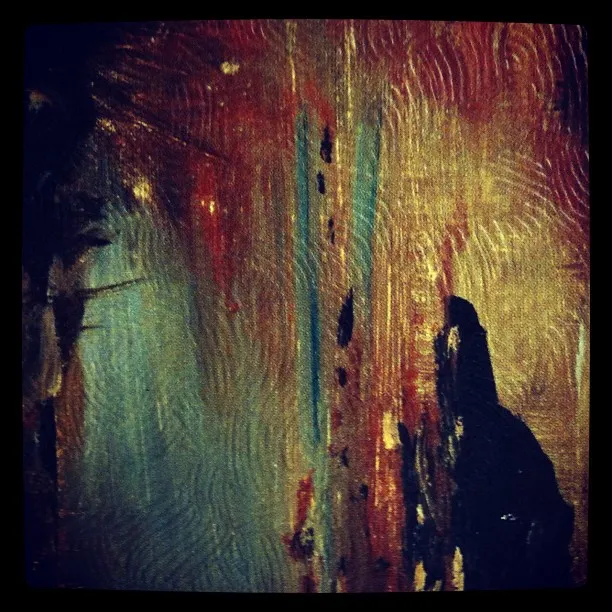 Close-up of a textured abstract painting with swirling brushstrokes in red, blue, gold, and black, showing visible canvas weave.