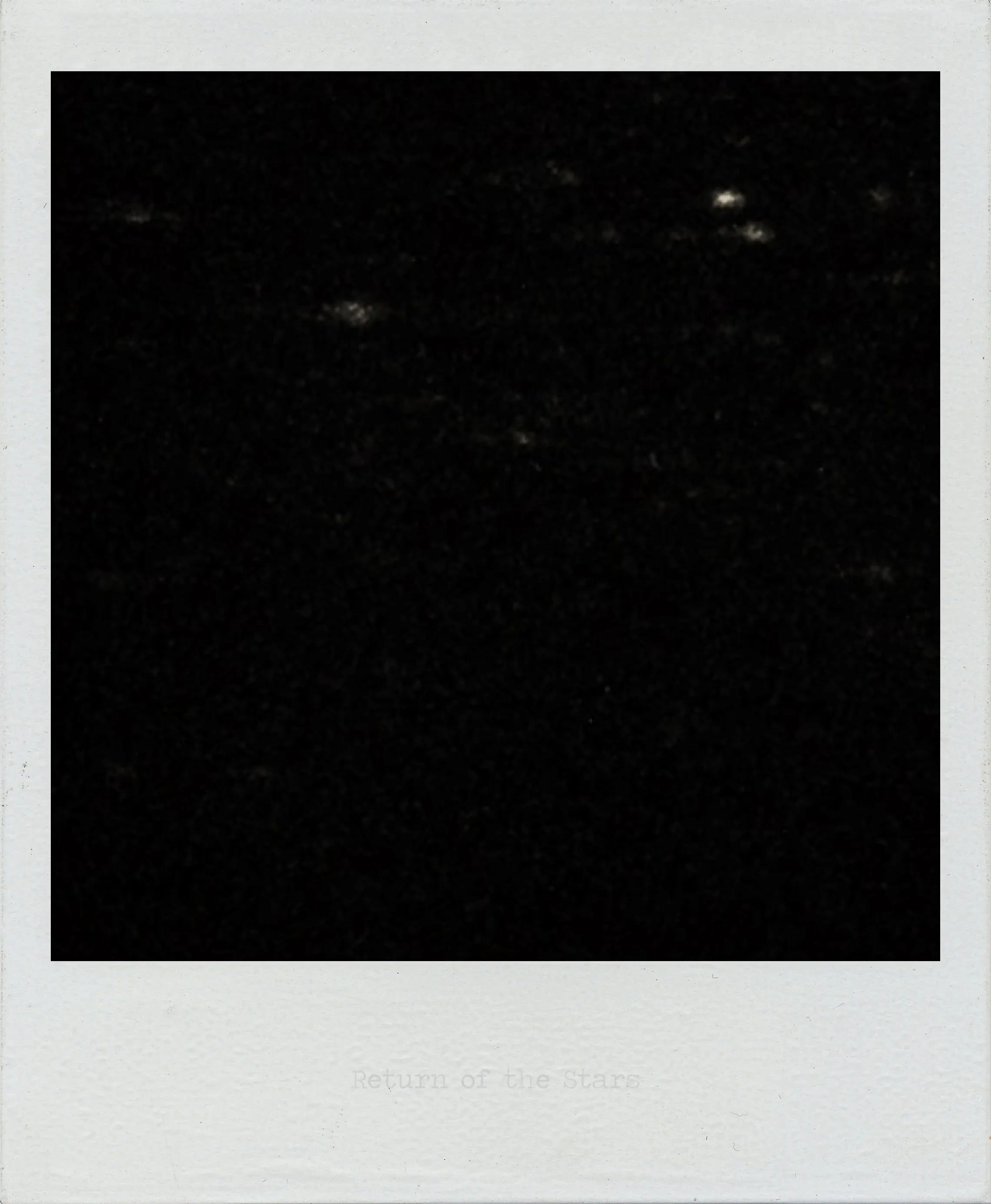 Dark image with scattered small white specks resembling stars against a mostly black background.