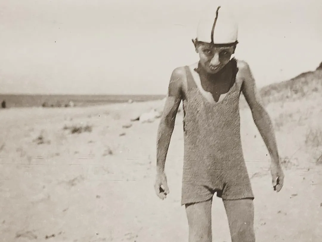 Vintage photograph of person wearing a bathing suit standing on beach